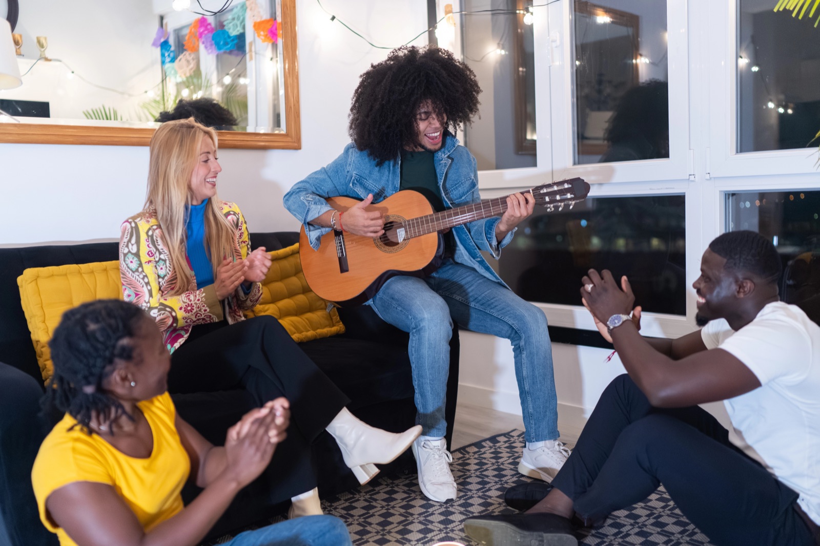 Groep vrienden zingt en klapt bij klassieke gitaarspel